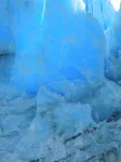 Quand un morceau de la falaise de glace tombe, il laisse apparaître de la glace vive avec qui joue le soleil.